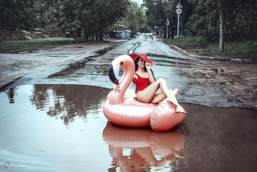 Девушка в купальнике добровольно села в лужу на дороге